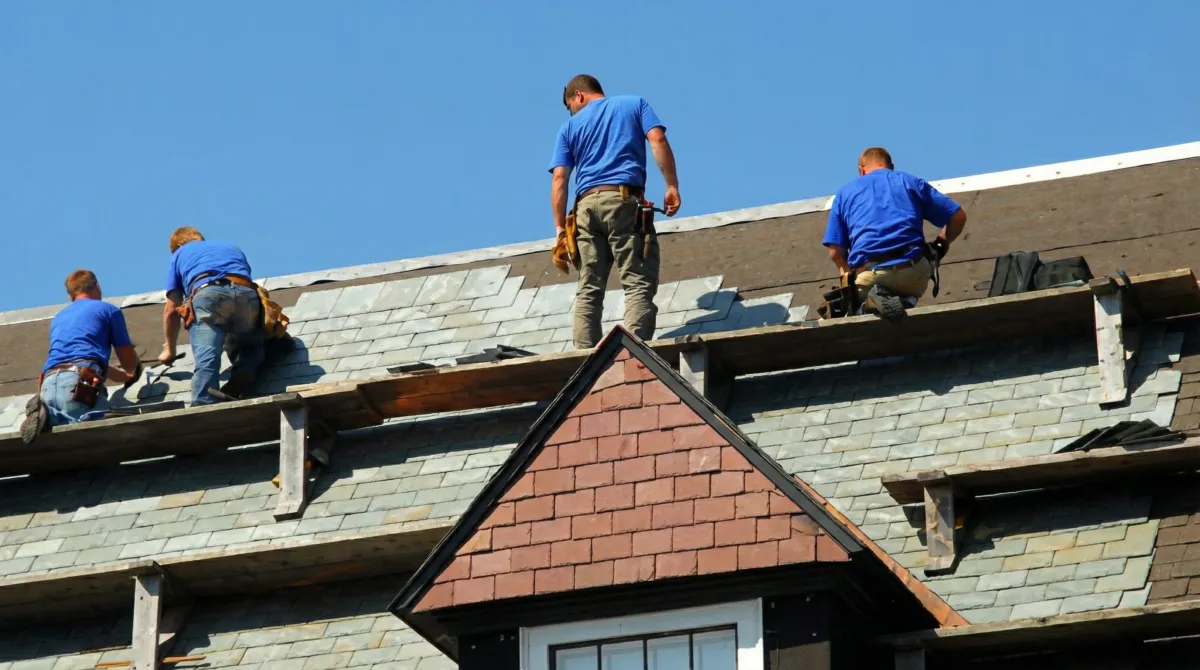 Roof replacement in progress with a team of professional contractors installing new shingles on a residential home in Newark, NJ